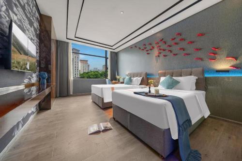 a hotel room with two beds and a couch at Xana Hotelle·Hotel Luzhou Baizitu Square in Luzhou