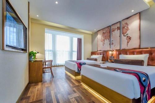 pokój hotelowy z dwoma łóżkami i telewizorem w obiekcie James Joyce Coffetel Chengdu Longquan Dongfang Huada Plaza w mieście Chengdu