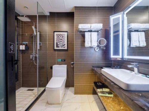 a bathroom with a sink and a toilet and a shower at Xana Hotelle·Yutian in Tangshan