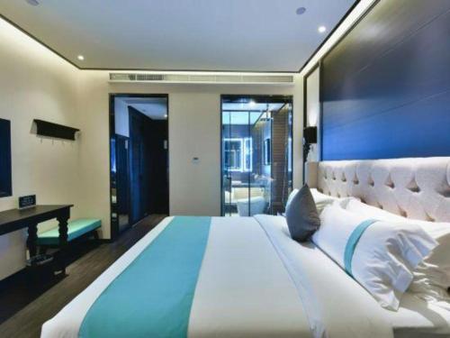 a large bedroom with a large bed with a blue accent at Xana Hotelle Chengdou Xindu Sanhechang Metro Station in Chengdu