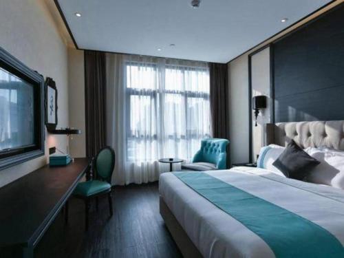a hotel room with a large bed and a television at Xana Hotelle Chengdou Xindu Sanhechang Metro Station in Chengdu