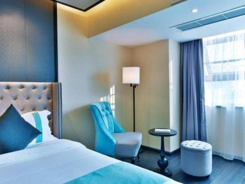 a bedroom with a bed and a chair and a window at Xana Hotelle Chengdou Xindu Sanhechang Metro Station in Chengdu