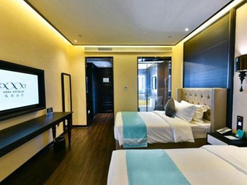 a hotel room with two beds and a flat screen tv at Xana Hotelle Chengdou Xindu Sanhechang Metro Station in Chengdu
