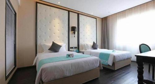 a hotel room with two beds and a piano at Xana Hotelle·Tianshui Shangyi Plaza in Tianshui