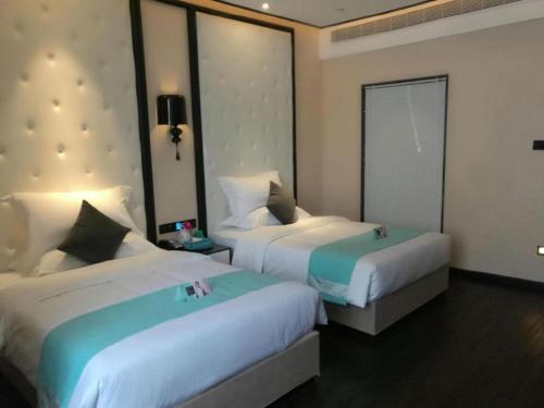 a hotel room with two beds and a window at Xana Hotelle·Tianshui Shangyi Plaza in Tianshui