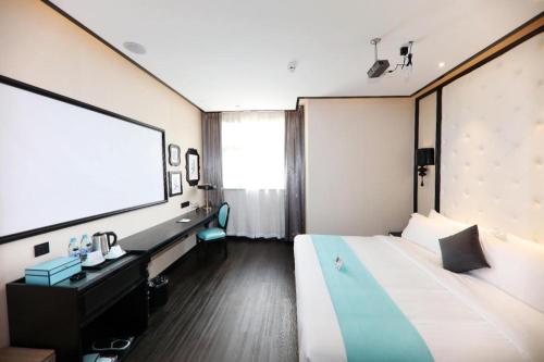 a hotel room with a large bed and a projection screen at Xana Hotelle·Tianshui Shangyi Plaza in Tianshui