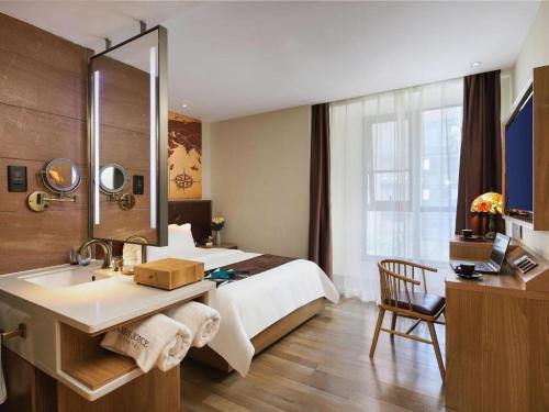 ein Hotelzimmer mit einem Bett und einem Waschbecken in der Unterkunft James Joyce Coffetel Zhengzhou CBD Exhibition Center Provincial People's Hospital in Zhengzhou