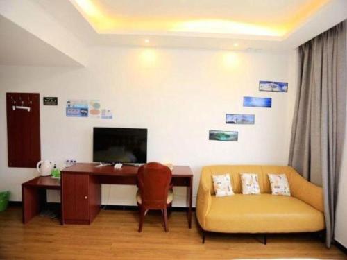 a living room with a desk and a couch and a table at Shell Linzhi Bayi Area G318 Shuangyong Road Hotel in Nyingchi