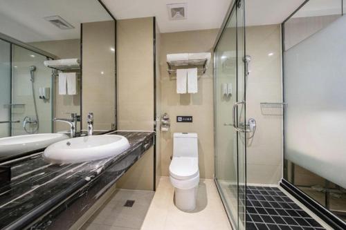a bathroom with a sink and a toilet and a shower at Borrman Hotel Wuhan Yangluo Metro Station Shenshuigang in Wuhan