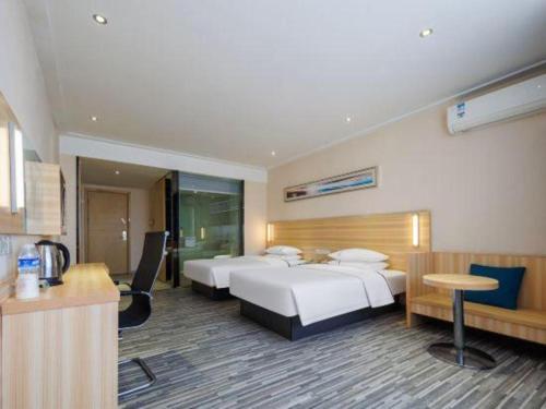 une chambre d'hôtel avec deux lits et un bureau dans l'établissement City Comfort Inn Wuhan Hongshan District Baishazhou Huangjiahu University Town, à Wuhan