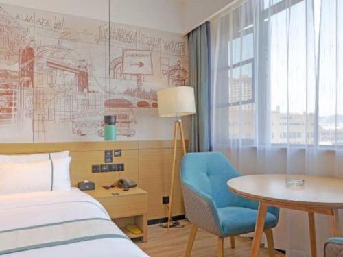una camera d'albergo con un letto, una scrivania e un tavolo di City Comfort Inn Taizhou International Exhibition Center a Ma-pu-ch'iao