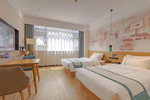 una camera d'albergo con due letti e una scrivania di City Comfort Inn Taizhou International Exhibition Center a Ma-pu-ch'iao