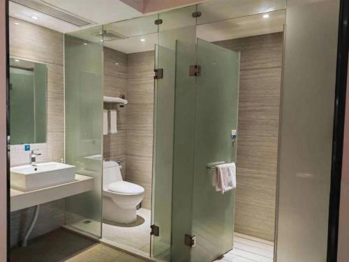 une salle de bain avec toilettes, lavabo et miroir dans l'établissement City Comfort Inn Jingzhou Railway Station Fantawild, à Caoshi