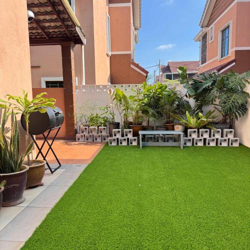 a garden with green grass and plants on a balcony at Cahaya Melissa Homestay Private Pool in Melaka