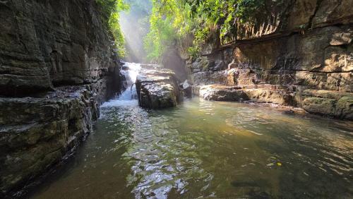 a river in a canyon with a waterfall at The Ridge House in Kandy