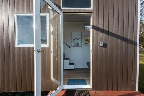 una porta che conduce in una casa con portico di Little Magic Tiny House by Tiny Away a Coolangatta