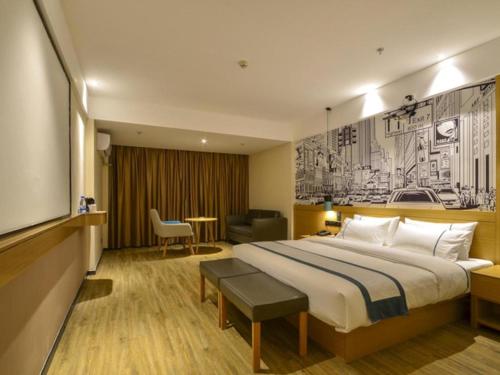 a hotel room with a large bed and a tv at City Comfort Inn Lichuan Railway Station Jimi Home in Enshi