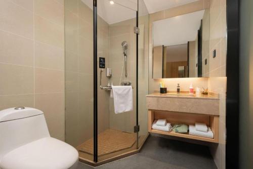 a bathroom with a shower and a toilet and a sink at City Comfort Inn Huangshi Bei Station in Huangshi