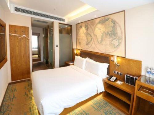 a bedroom with a large white bed and a desk at James Joyce Coffetel Changchun People's Square in Changchun