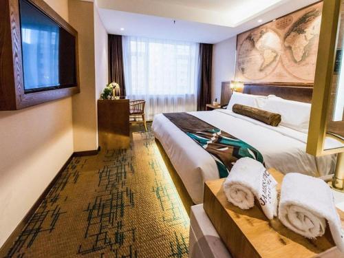 a hotel room with a large bed and a table at James Joyce Coffetel Changchun People's Square in Changchun