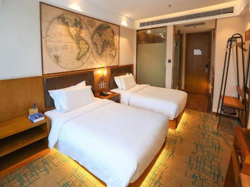 a hotel room with two beds and a map on the wall at James Joyce Coffetel Changchun People's Square in Changchun