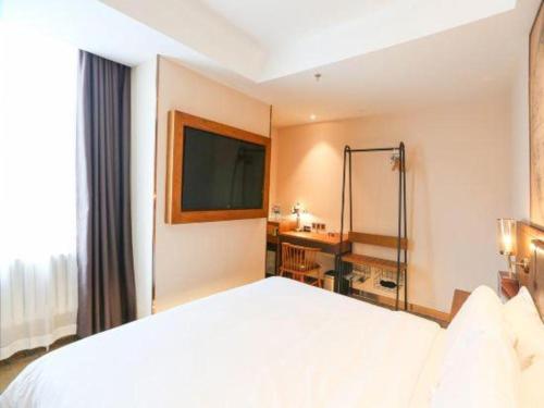 a hotel room with a large bed and a bathroom at James Joyce Coffetel Changchun People's Square in Changchun