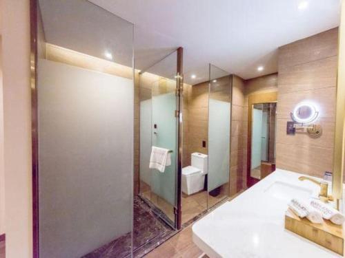 a bathroom with a glass shower and a sink at James Joyce Coffetel Changchun People's Square in Changchun