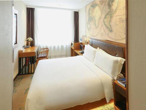 a bedroom with a large bed and a map on the wall at James Joyce Coffetel Changchun People's Square in Changchun