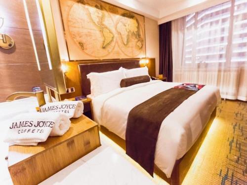 a hotel room with a large bed and a window at James Joyce Coffetel Changchun People's Square in Changchun