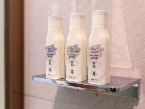 a group of four bottles on a shelf in a bathroom at Lavande Hotels Wuhan Guanggu Yangjiawan Metro Station in Wuhan