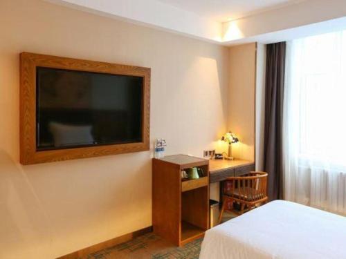 a hotel room with a flat screen tv on the wall at James Joyce Coffetel Changchun People's Square in Changchun