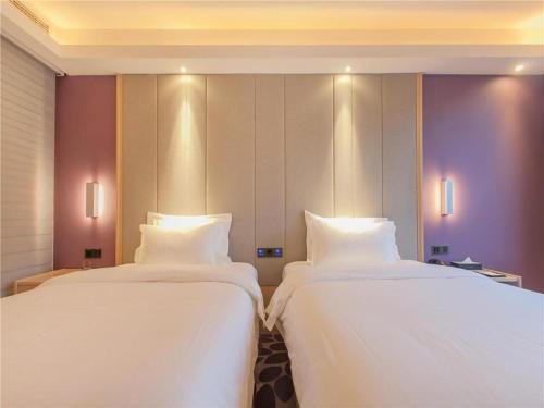 two beds sitting next to each other in a room at Lavande Hotels Wuhan Guanggu Yangjiawan Metro Station in Wuhan