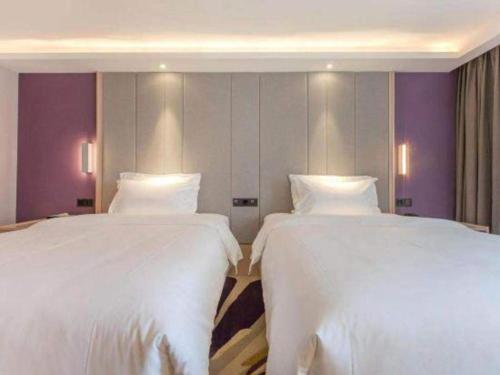 two beds sitting next to each other in a room at Lavande Hotels Wuhan Guanggu Yangjiawan Metro Station in Wuhan