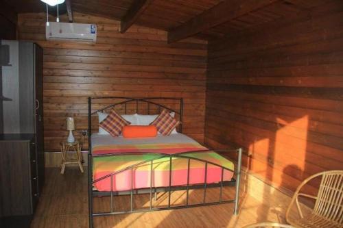 a bedroom with a bed in a wooden room at Ma-Oya Retreat in Pinnawala