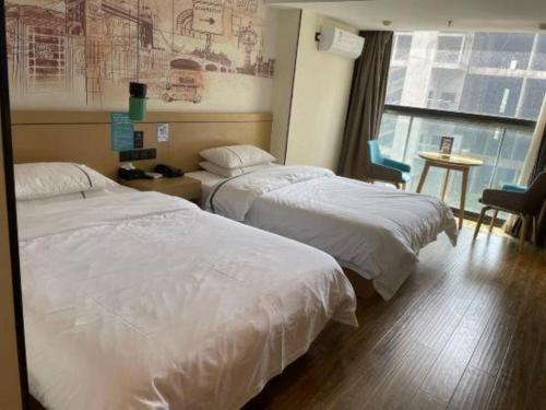 a hotel room with two beds and a window at City Comfort Inn Kunming High Speed Railway South Station Yongxin Harvard in Kunming