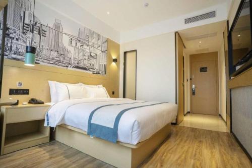 a hotel room with a large bed and a television at City Comfort Inn Changsha South Railyway Station West Square in Changsha