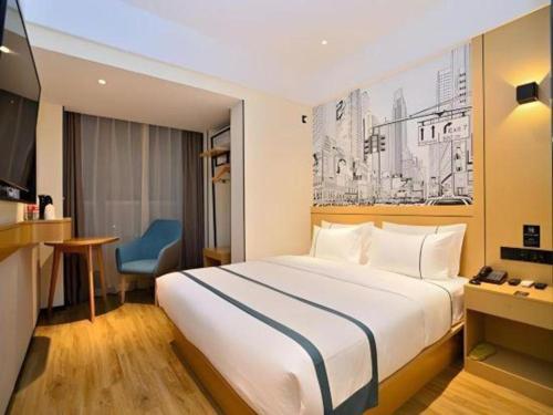a hotel room with a white bed and a blue chair at City Comfort Inn Kunming High Speed Railway South Station Yongxin Harvard in Kunming
