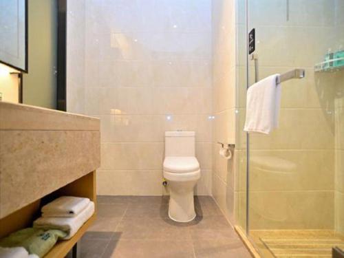 a bathroom with a toilet and a glass shower at City Comfort Inn Kunming High Speed Railway South Station Yongxin Harvard in Kunming