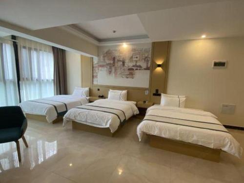 a hotel room with three beds in a room at City Comfort Inn Kunming High Speed Railway South Station Yongxin Harvard in Kunming