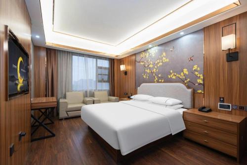 une chambre avec un grand lit blanc et un salon dans l'établissement City Comfort Inn Xianning Yinquan Avenue, à Wenquanzhen