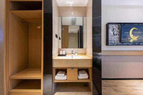 une salle de bain avec un lavabo et un miroir dans l'établissement City Comfort Inn Xianning Yinquan Avenue, à Wenquanzhen
