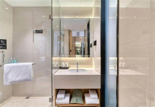 une salle de bain avec un lavabo et une douche dans l'établissement City Comfort Inn Zhangjiakou Municipal Government High-speed Railway Station North Institute, à Dongyaozi