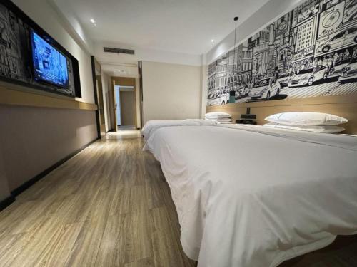 a bedroom with two beds and a flat screen tv at City Comfort Inn Shiyan Wudang Mountain in Danjiangkou