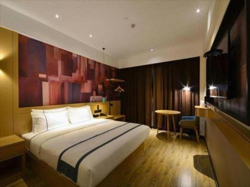 a hotel room with a bed and a television at City Comfort Inn Shiyan Wudang Mountain in Danjiangkou