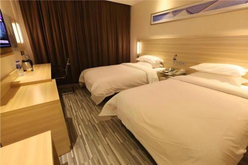 a hotel room with two beds and a television at City Comfort Inn Liuzhou Liucheng in Liuzhou