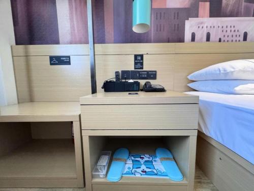 a bedroom with a bed and a desk with at City Comfort Inn Shiyan Wudang Mountain in Danjiangkou
