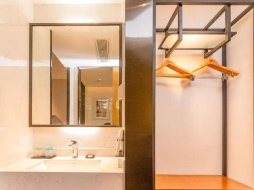 łazienka z umywalką i lustrem w obiekcie Borrman Hotel Dongguan Dongcheng Wanda Plaza Tianbao Metro Station w mieście Dongguan