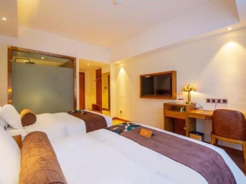 a hotel room with two beds and a desk at James Joyce Coffetel Kunming Railway Station Huancheng Nan Road Metro Station in Kunming