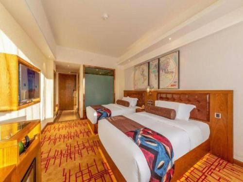 a bedroom with two beds and a kitchen at James Joyce Coffetel Kunming Railway Station Huancheng Nan Road Metro Station in Kunming