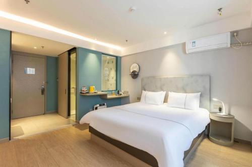 a large white bed in a hotel room at Magnotel Hotel Suzhou Wanda Plaza Huaihai Road in Suzhou